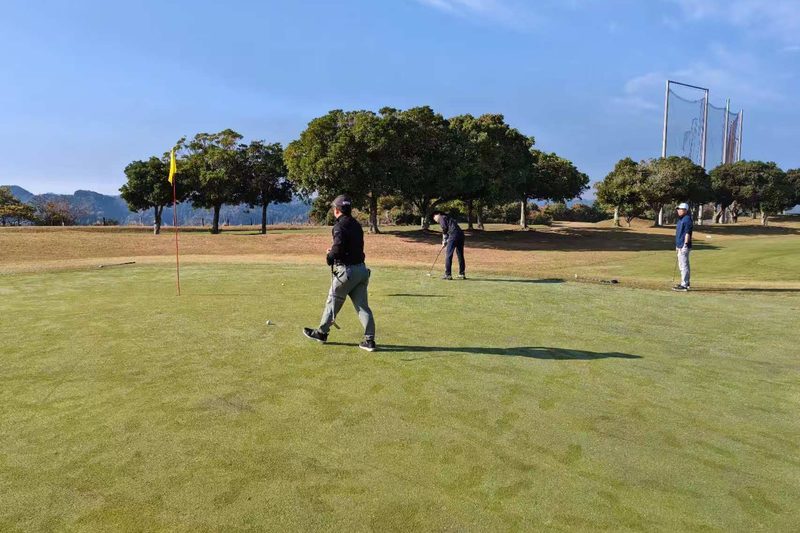 同好会成员在果岭上等待推杆